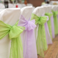 White wedding chairs with silk ribbons